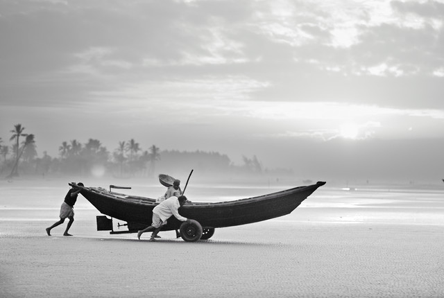 FISHERMEN LAUNCHING THEIR BOAT IN THE MORNING, BANGLADESH von Jakob Berr